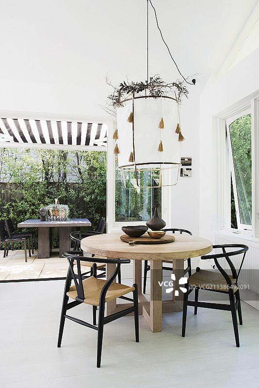 设计师的桌子配椅子，吊灯上方用叶花环点缀在餐厅里图片素材