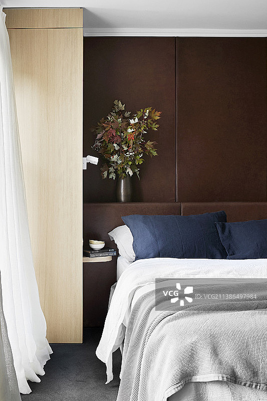 卧室的床后面有带壁架的棕色镶板图片素材