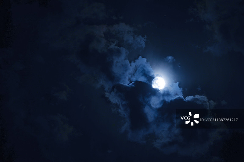 夜空中一轮满月被云雾环绕图片素材