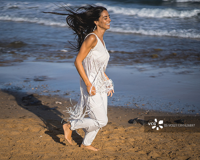 美丽的年轻女子穿着比基尼在海滩上度过一天的日落图片素材
