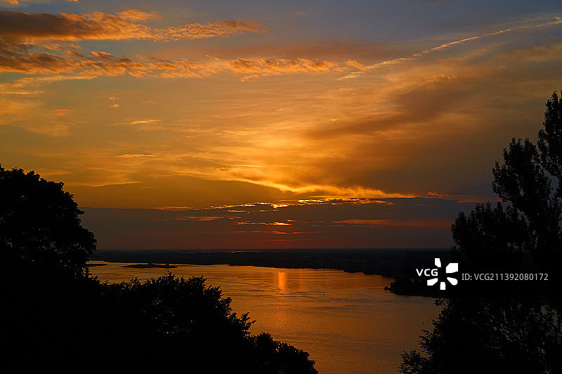 俄罗斯下诺夫哥罗德州下诺夫哥罗德市，在黄金时间里，五彩缤纷的日落天空在河上图片素材
