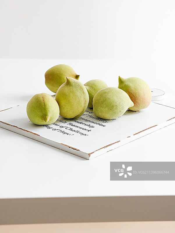 白色桌面上摆放着新鲜夏日水果桃子图片素材