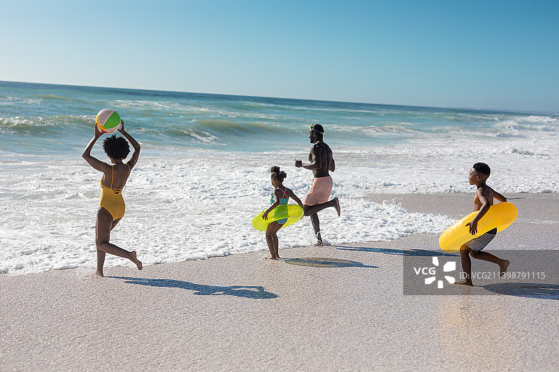 阳光明媚的日子，非洲裔美国父母和孩子在海滩上玩耍图片素材