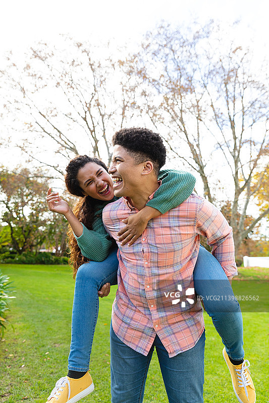 一对幸福的混血夫妇在花园里互相背着笑得很开心图片素材