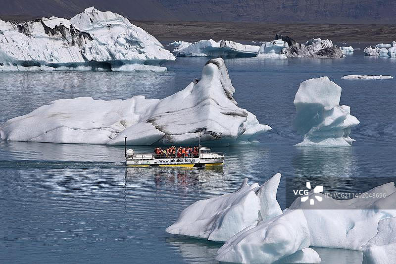 欧洲冰岛霍纳费约杜尔的瓦特纳约库尔国家公园，游客乘坐两栖车在约库尔萨隆冰川泻湖的冰山之间穿梭图片素材