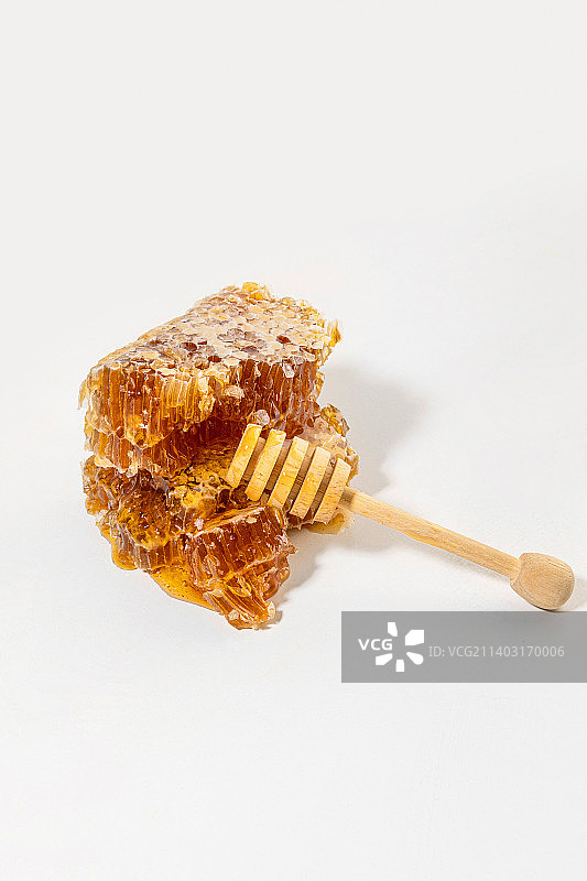 切片蜂巢和蜂蜜勺棒图片素材