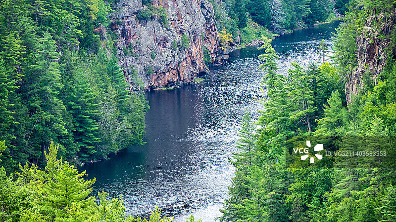 加拿大阿尔冈昆省立公园，森林中树木间河流的高角度景观图片素材