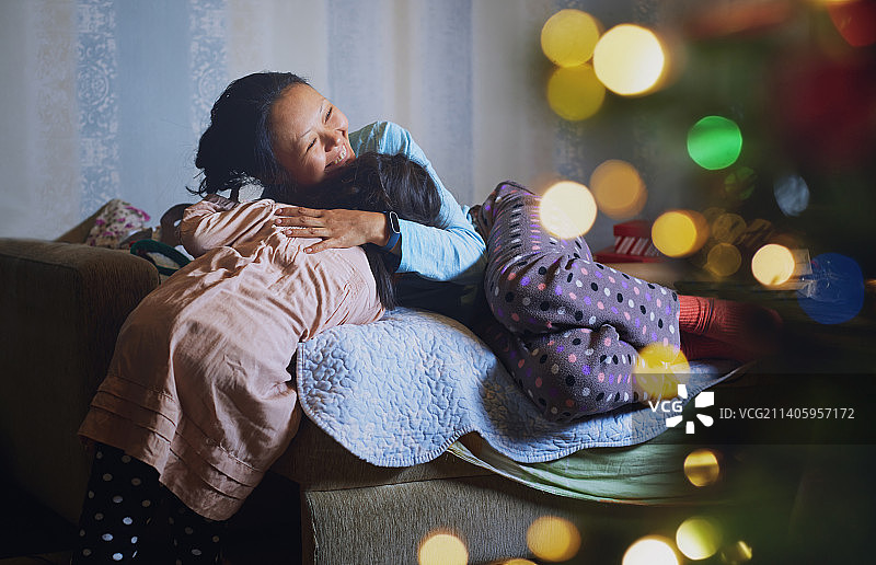 在为圣诞节装饰的家中拥抱的母亲和女儿图片素材