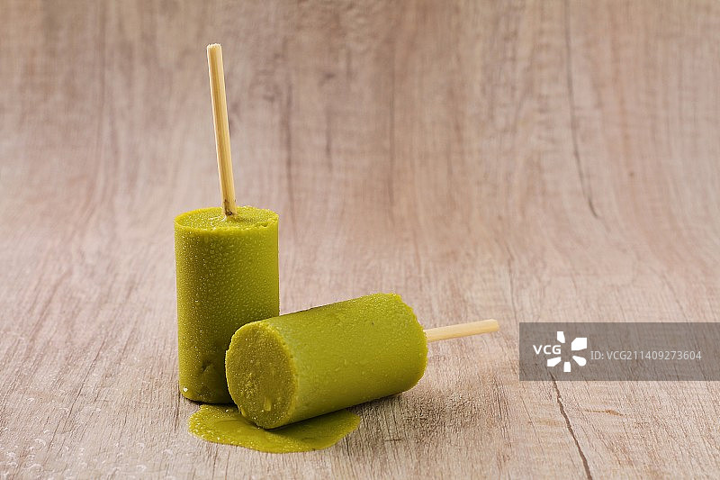 绿色冰沙冰棒的特写与木棍放在桌子上，贝卡西，印度尼西亚图片素材