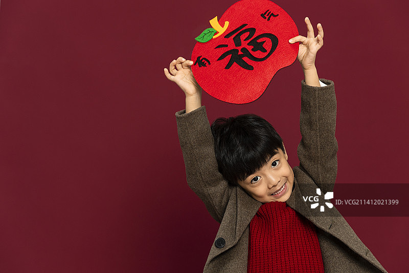 儿童庆祝春节系列：欢乐的小男孩拿着福字庆祝新春图片素材