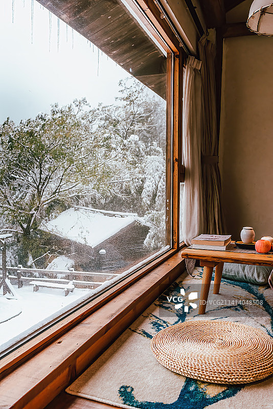 民宿室内的沙发茶几和窗外的雪景图片素材
