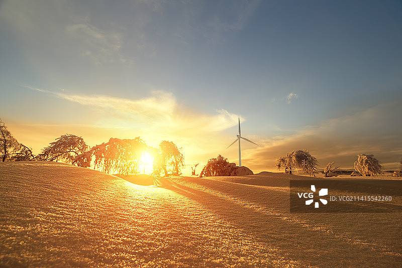 寒冷的冬天坝上草原雪后风电厂唯美夕阳朝霞照射在雪地上图片素材