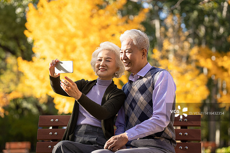 老年夫妇使用手机拍照图片素材
