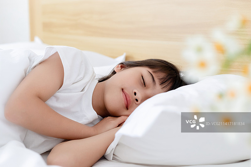 一个中国小女孩在床上睡觉图片素材