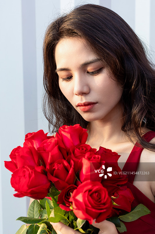 一名手拿着一束红色玫瑰花的中国美女图片素材