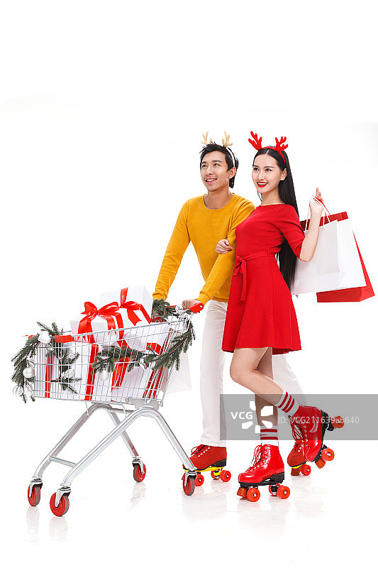圣诞节推着购物车的年轻情侣图片素材