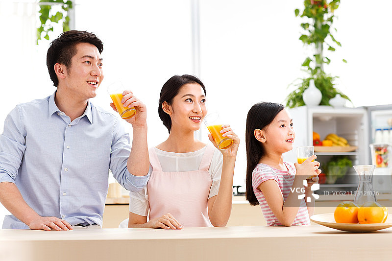 幸福的一家三口在喝果汁图片素材