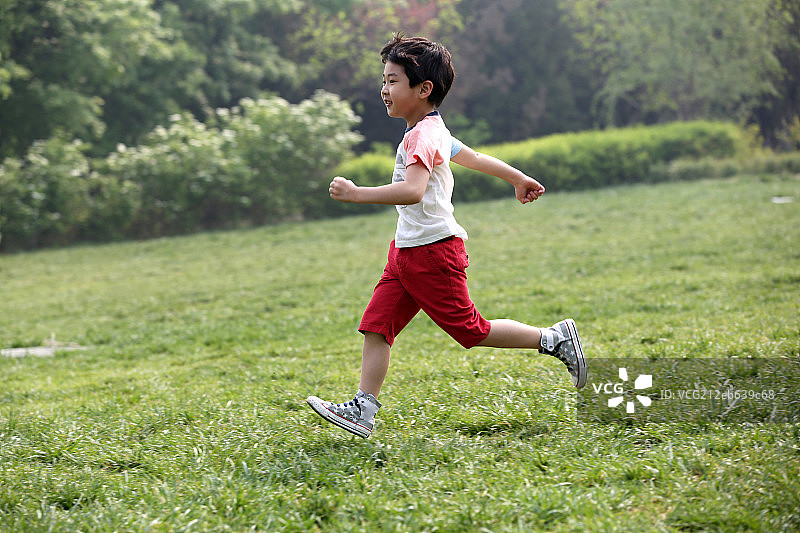 小男孩在草地上奔跑图片素材