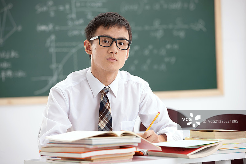一个戴着眼镜的中学男生坐在教室里图片素材