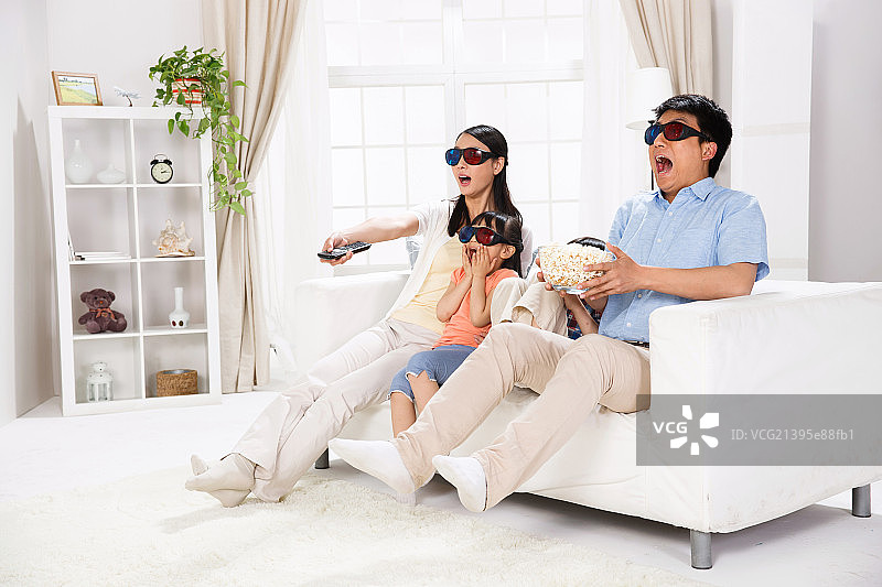 一家四口戴着3D眼镜在客厅里看电影图片素材