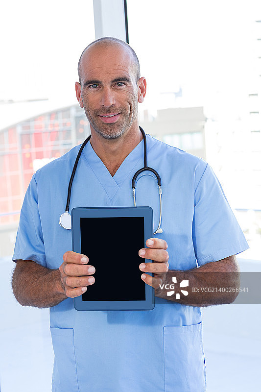 微笑的医生拿着平板电脑在医务室图片素材