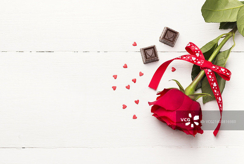 红玫瑰，白木色背景上的巧克力图片素材
