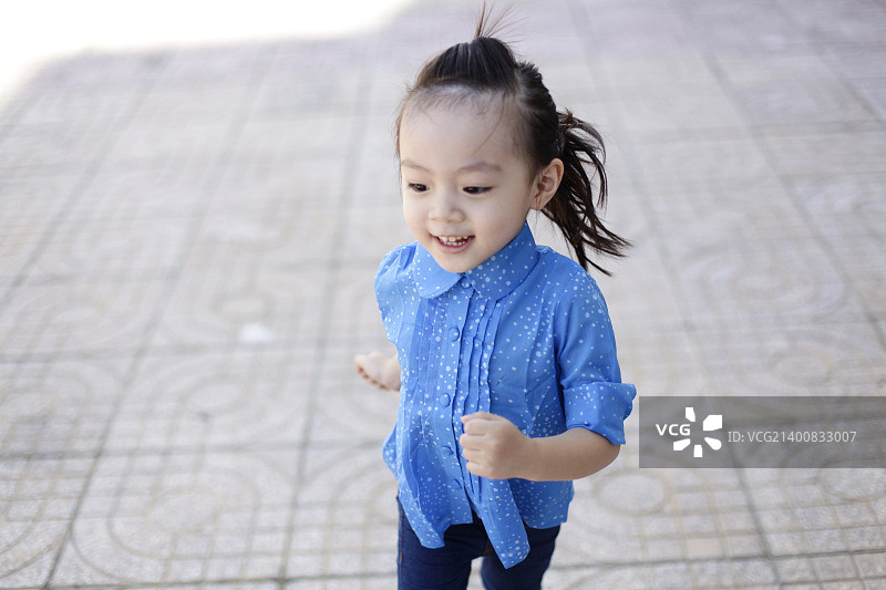 可爱可爱甜美的亚洲中国小女孩与微笑的脸在路上图片素材