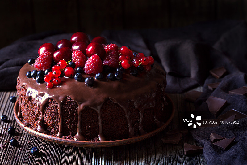 传统的自制巧克力蛋糕甜点与棕色糖霜，樱桃，覆盆子，curr图片素材