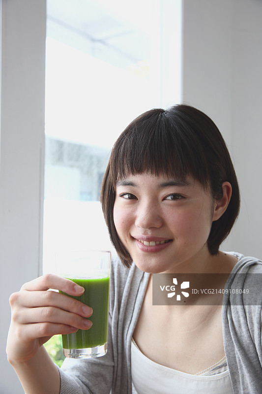 年轻的日本女人在通风的房间喝酒图片素材