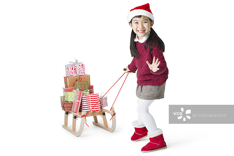 小女孩拉着雪橇运送圣诞礼物图片素材