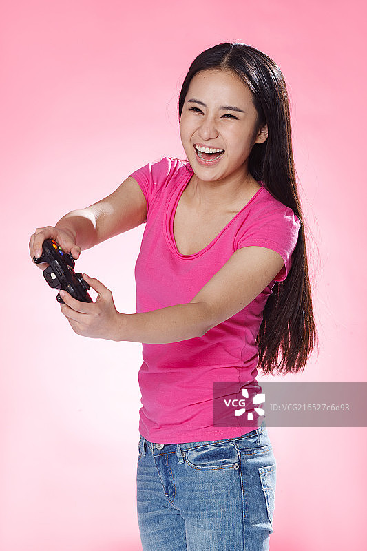 青春活力的年轻女孩玩游戏机图片素材