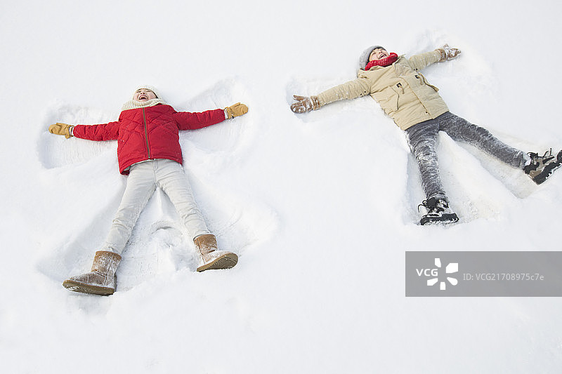 两个小孩躺在雪地上图片素材