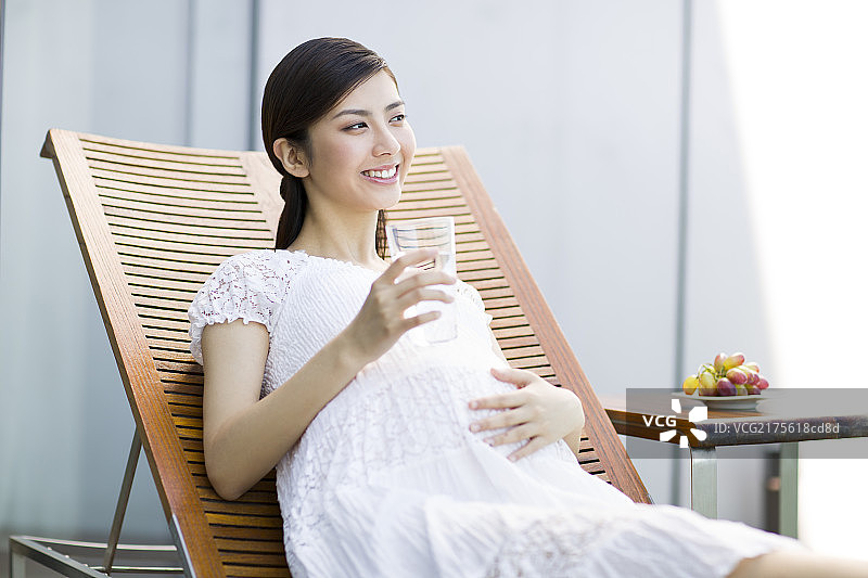 孕妇靠在躺椅上喝水图片素材