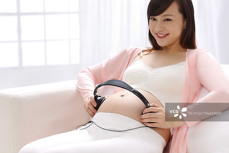 孕妇把耳机放在肚子上图片素材
