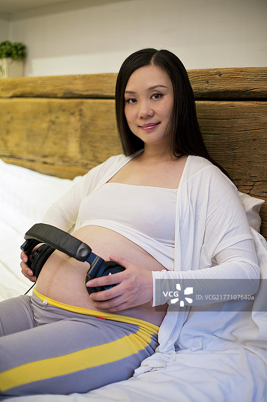 孕妇把耳机放在肚子上图片素材