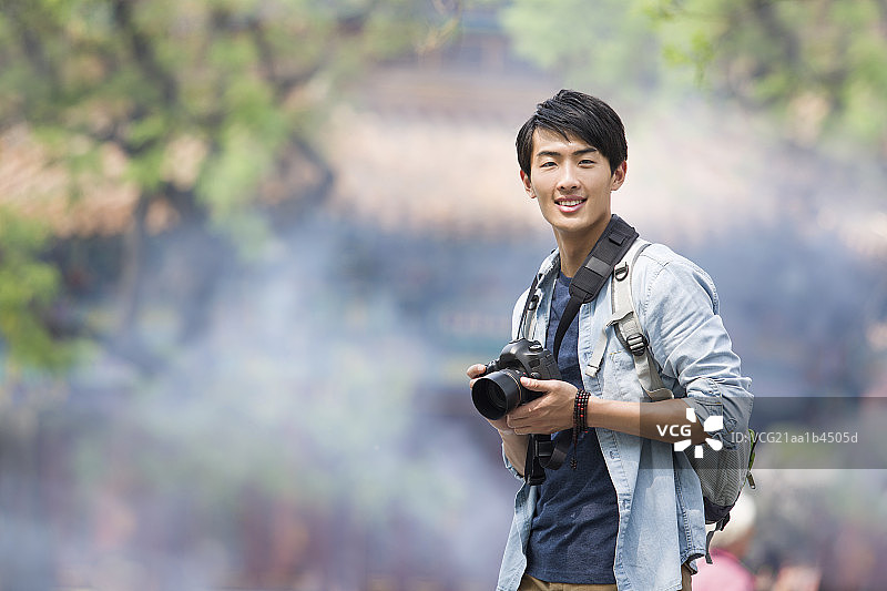 年轻男子拿着相机在雍和宫旅游图片素材