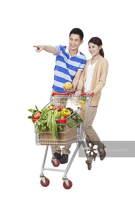 一对青年男女合推一辆装满蔬菜的购物车图片素材