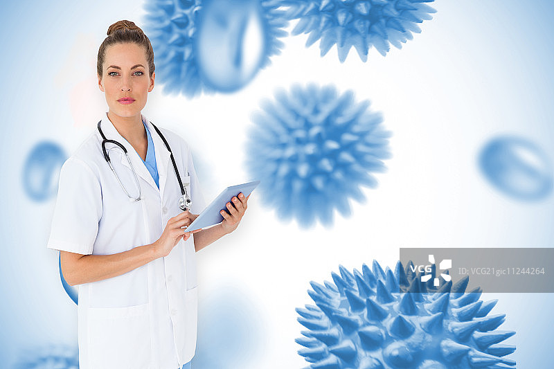 漂亮护士用平板电脑对付蓝色病毒细胞图片素材