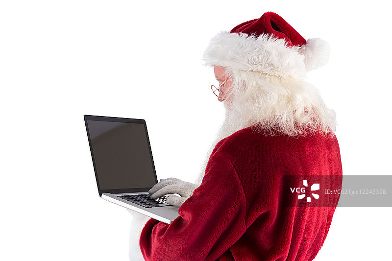 圣诞老人用一台白色背景的笔记本电脑图片素材