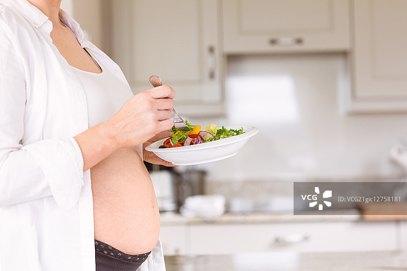 孕妇在家厨房里吃沙拉图片素材