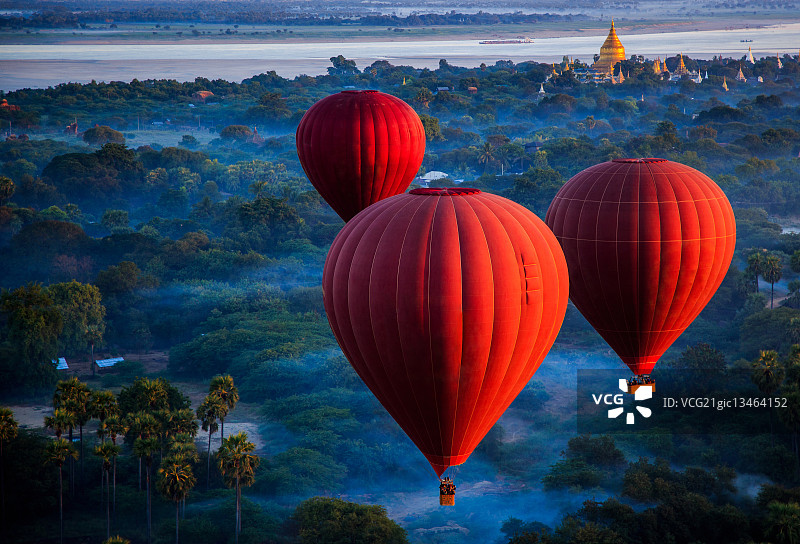 红色热气球在缅甸曼德勒地区nyung - u的丛林上空图片素材