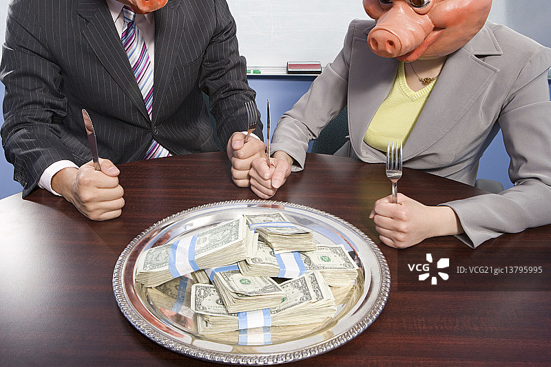 戴着猪面具的商人坐在钱前面图片素材