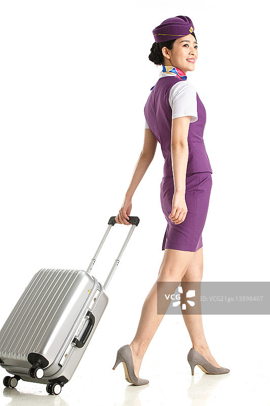 青年女乘务员拉着行李箱图片素材