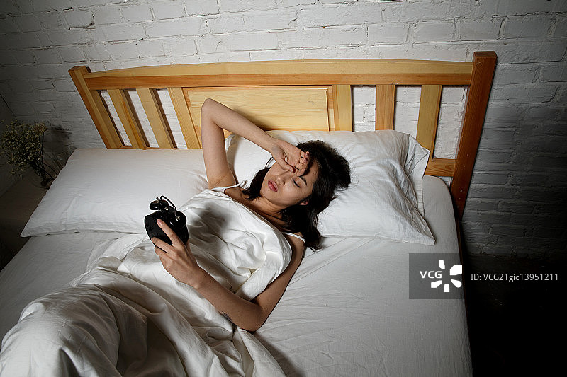 青年女人躺在床上失眠图片素材