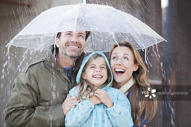 热情的家人在倾盆大雨的伞下图片素材