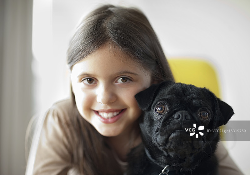 微笑的女孩抱着狗图片素材