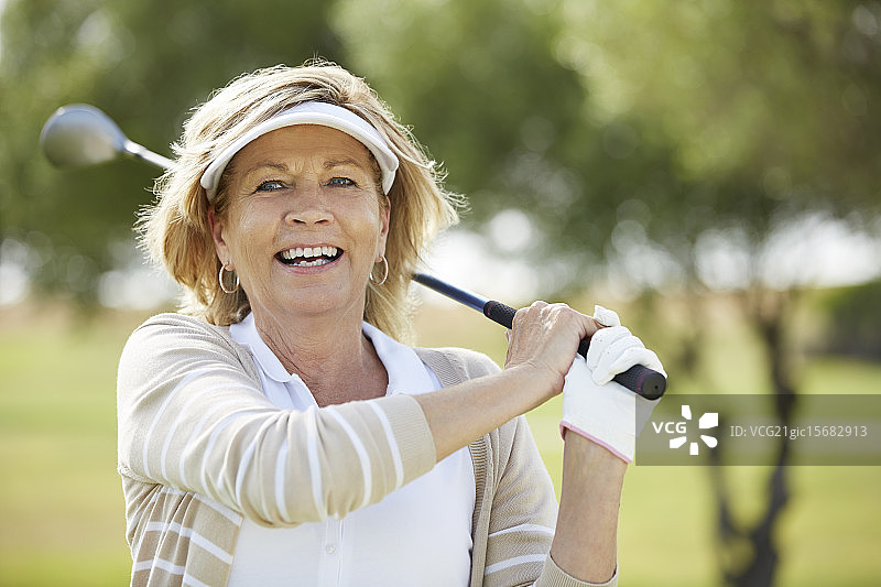 在球场上打高尔夫的老妇人图片素材