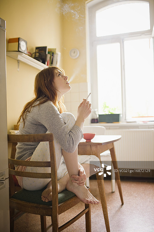 女人在厨房吸烟的肖像图片素材