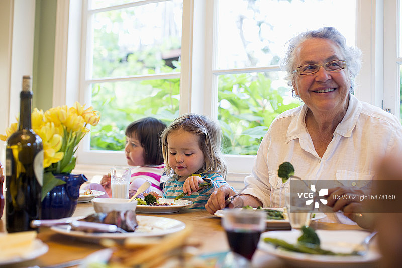 两个孙女(2- 3,4 -5)和奶奶一起吃晚餐，美国加州图片素材
