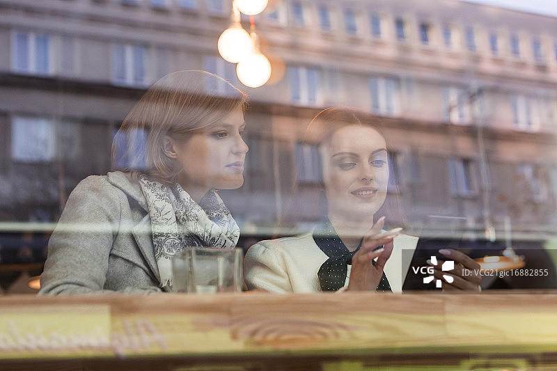 商务女性在咖啡馆窗口使用手机图片素材